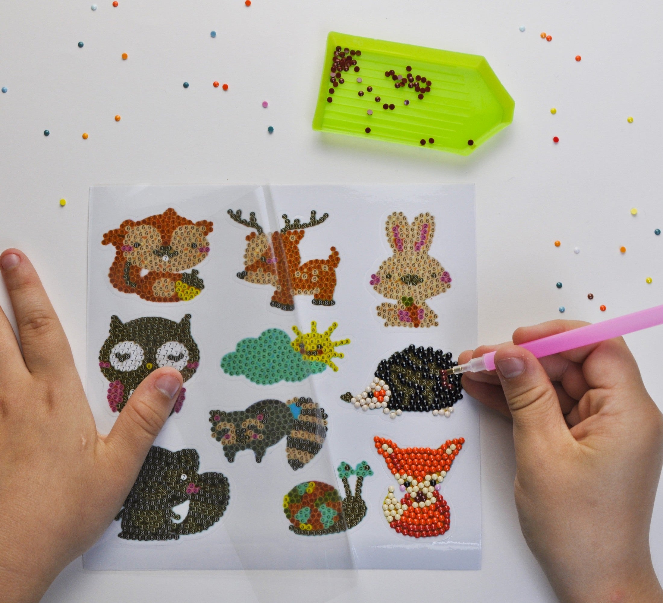 Kinder gestalten ein kreatives Diamond Painting Sticker Bastelset mit Waldtier-Motiven wie Hase, Eule und Igel, funkelnden Diamantsteinen und praktischem Zubehör