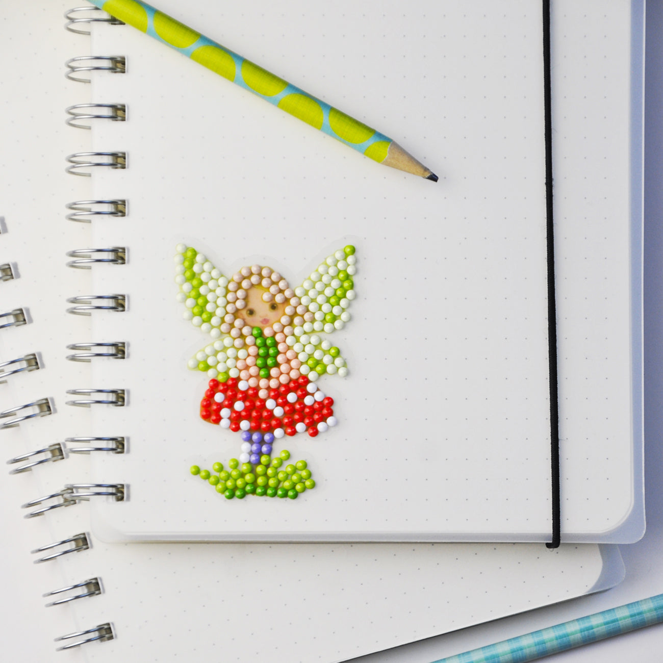 Fertiger Diamond Painting Sticker mit Fliegenpilz-Fee als zauberhafte Dekoration auf einem Notizbuch