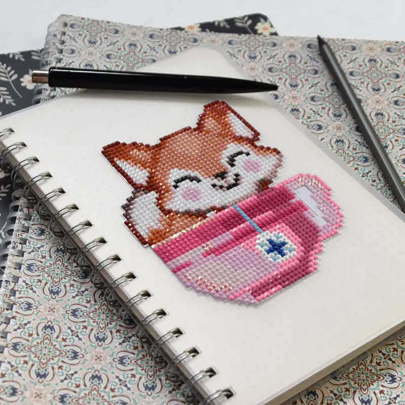 Diamond Painting Sticker mit Fuchs-Motiv in rosa Trinkbecher auf Notizbuch