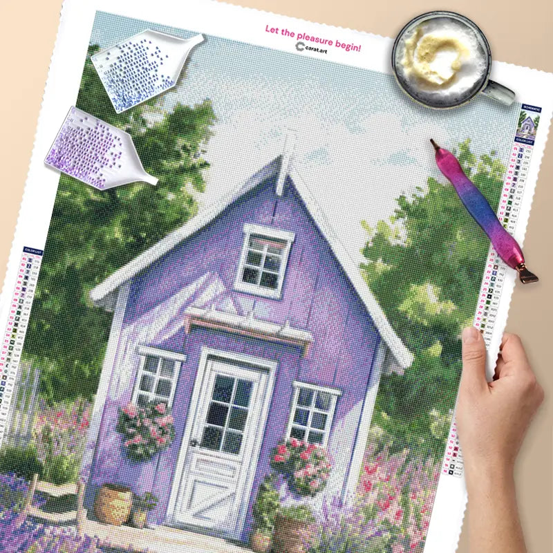 Diamond Painting Leinwand mit Steinchen, Diamond Painting Stift und Schiffchen mit einem blumigen Motiv eines Häuschens, umgeben von Lavendelfeldern und Rosen